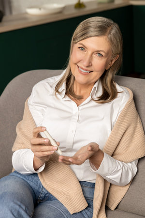 Smiling diabetic woman checking her blood sugar and looking relaxed