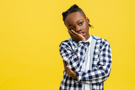 Kid in checkered shirt looking tired and sleepyの写真素材