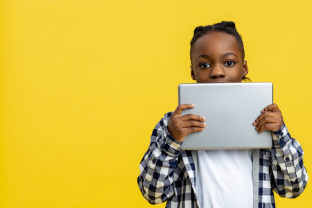 African american boy in checkered shirt with tablet in handsの写真素材