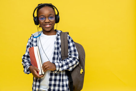 African american boy with backpack and book in hands