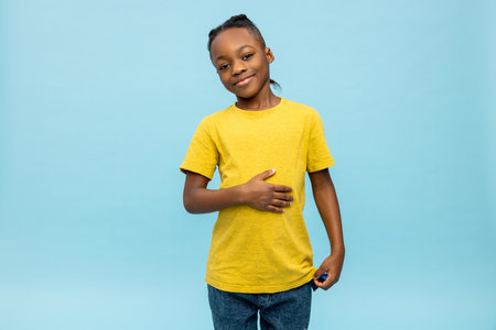 Cute dark-skinned boy laughing hard and looking enjoyedの写真素材