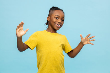 Dark-skinned boy in yellow tshirt looking excited and happy