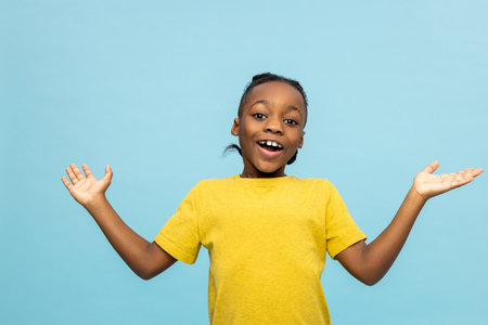 Dark-skinned boy in yellow tshirt looking excited and happy