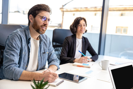 Coworkers with laptop having meeting in office