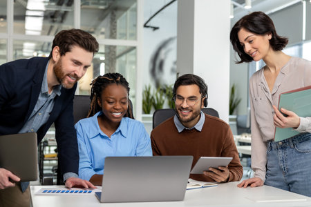 Happy diverse businesspeople collaborating on new project on laptop in office