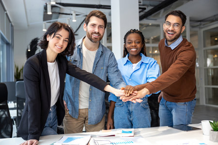 Happy diverse businesspeople collaborating on new project holding hands in boardroomの写真素材