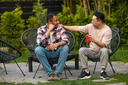 Cheerful friends enjoying cold beer at backyard partyの写真素材