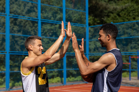 Basketball players playing together on summer playgroundの写真素材
