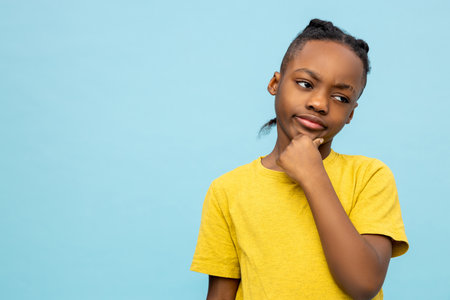 Cute african american boy in yellow tshirt looking serious