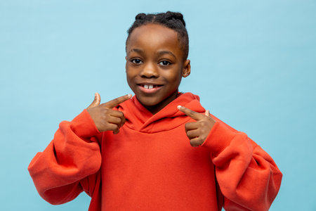 Sweet dark-skinned kid gesticulating and looking happy