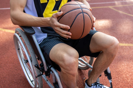 Anonymous man basketball player in wheelchair holding basketball ballの写真素材