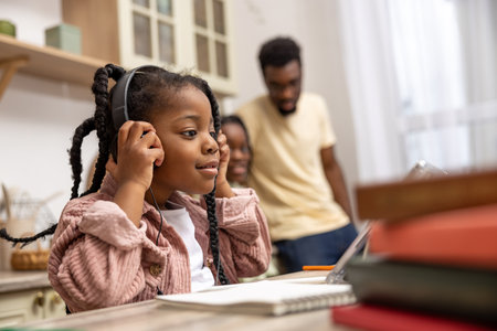 Little female pupil using her tablet for remote learning attending online classes