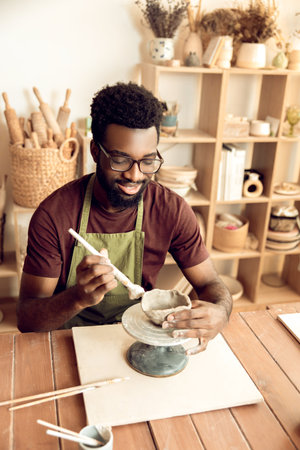 Smiling man painting pottery and looking enjoyedの写真素材