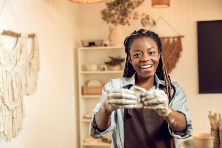 Smiling young woman with a new clay mug in handsの写真素材