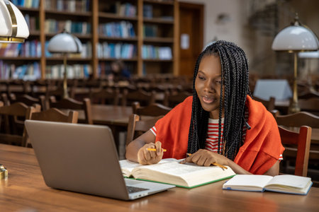 Long-haired young woman in red clothes studying in the library