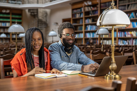 Dark-skinned couple studying together in the library