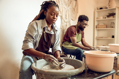 Man and woman having a pottery workshop and looking involved