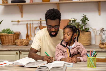 Young dad explaining kid daughter learning doing homeworkの写真素材