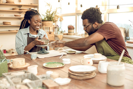 Two people looking involved while working with new pottery