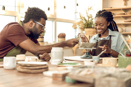 Two people working with pottery and looking involvedの写真素材