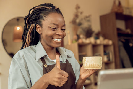 Smiling female sculptor holding a new mug in handsの写真素材