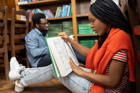 Young people studying in the library together and looking involved