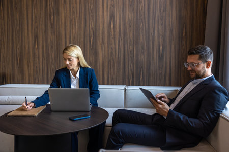 Professional coworkers working on laptop and tablet in office discussing new ideas