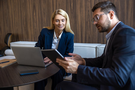 Businesspeople using laptop working together in modern workspaceの写真素材