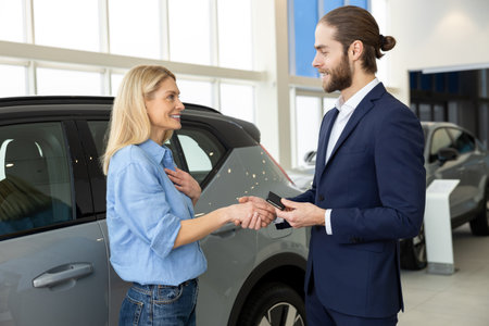 Male sale assistant talking to a female customer in a dealership