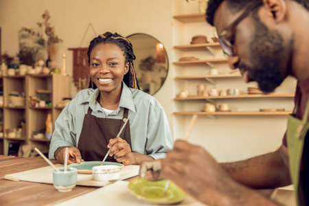 Young woman at the workshop working with ceramic plate