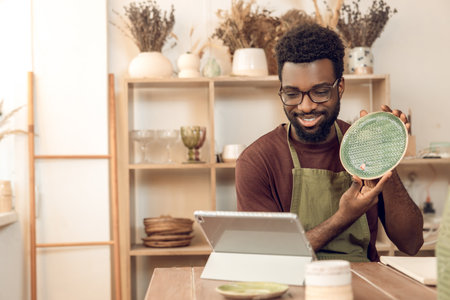 African american sculptor conducting a n online tutorial and looking contented