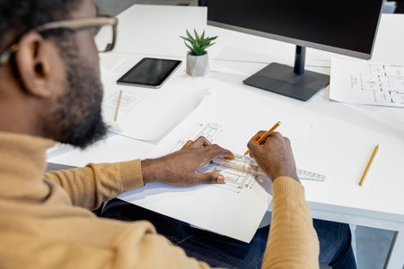 Skillful man architect creating blueprints for new projects on computer in his workplaceの写真素材