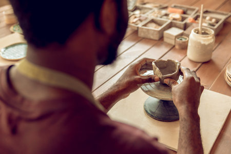 African american man working with clay and looking involved.の写真素材