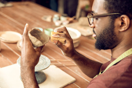 Close up picture of sculptors hands working with a clay mugの写真素材