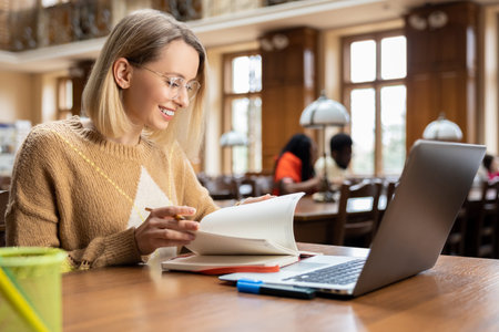 Smiling pretty woman working in the library