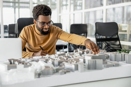 Architect working on miniature project and looking inspired