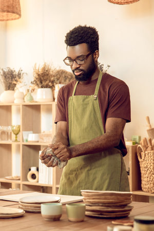African american sculptor working with clay and looking involved