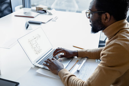 Hard working man architect handling creative projects on laptop in the office