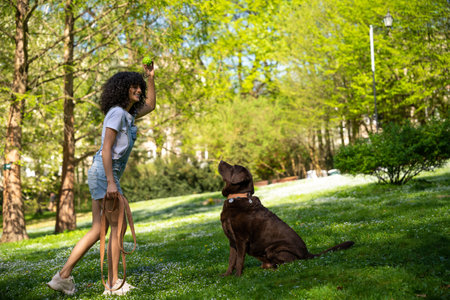 Slim young caucasian woman with a dog in the parkの写真素材
