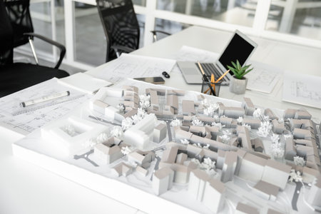 Empty architect workplace with blueprints and laptop in office