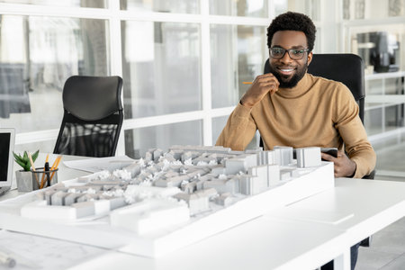 Successful man architect reviewing blueprints in his workplaceの写真素材