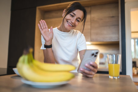 Cute smiling young woman at home having a call on the phoneの写真素材