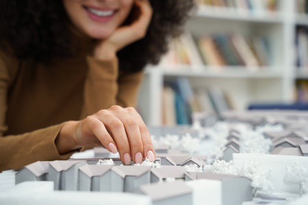 Female architect focused on designing architectural layouts at library desk