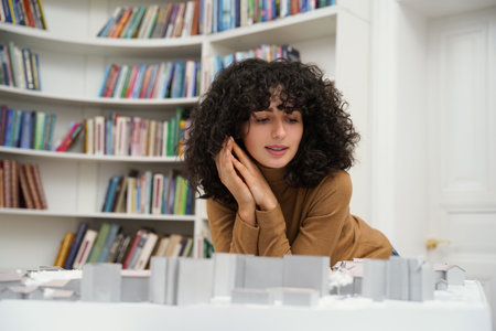 Focused young woman architect student working on diploma project in university libraryの写真素材