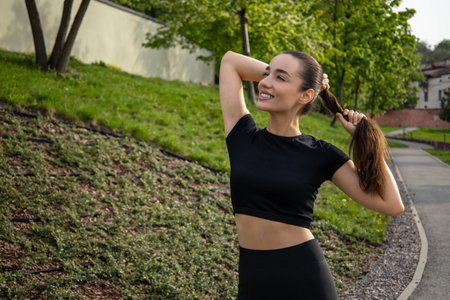 Fitness woman doing stretching exercises before outdoor workout in parkの写真素材