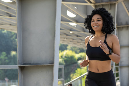 Brunette woman in black top running and looking concentrated