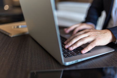 Closeup of businessman hands typing on keyboard on laptop computerの写真素材
