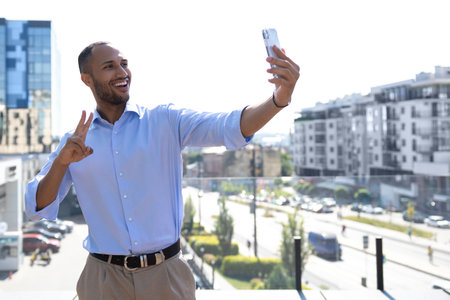 Smiling young businessman using mobile phone in city having video call