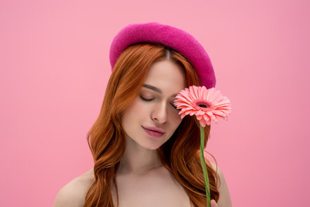 Portrait of a young beautiful ginger woman with a flower in handsの写真素材