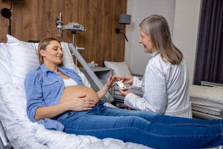 Doctor measuring pregnant womans level of glucose with glucometerの写真素材